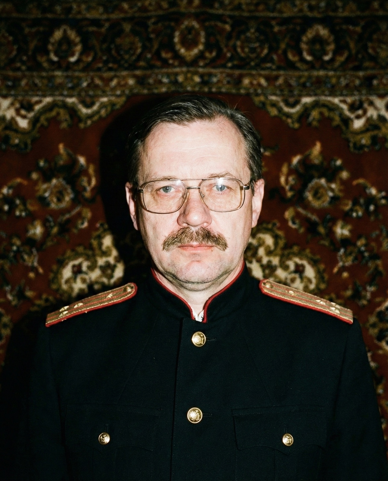 O'Brien in uniform, photographed with direct flash against the ornamented rug